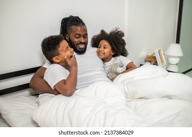 Man Hugging Yawning Boy And Smiling Girl