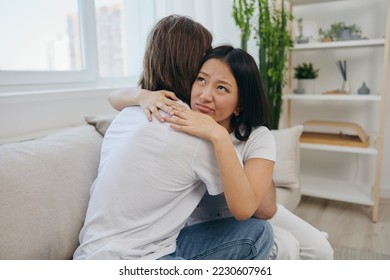 A man hugs his Asian woman friend at home. Psychological support for a friend - Shutterstock ID 2230607961