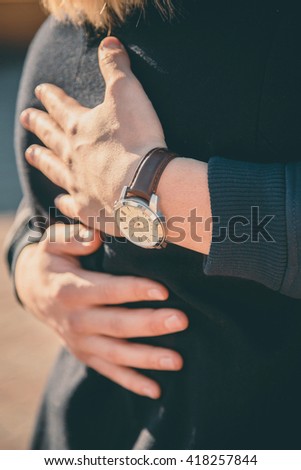 Man hugs his girlfriend at sunset. Girl in man's arms. Close up of couple