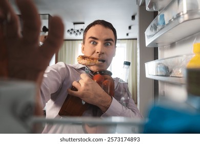 Man hungry guy open empty refrigerator point of view from inside fridge. A businessman looks for food in the fridge and chooses what to eat.