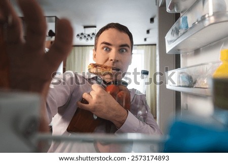 Man hungry guy open empty refrigerator point of view from inside fridge. A businessman looks for food in the fridge and chooses what to eat.
