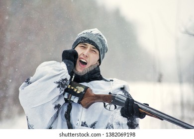 Man (hunter) In Winter Camouflage Hit The Butt Of A Gun In The Chin From The Recoil When Fired