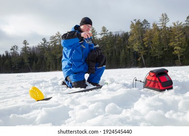 Man Ice Fishing On A Northern Minnesota Lake On A Sunny Winter Morning