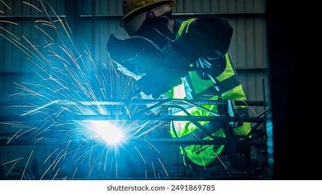 Man Industrial welder worker using a welding torch on metal in a factory. welding worker team working arc weld metal joint production in heavy industry danger and risk workplace with eyes safety. - Powered by Shutterstock