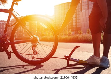 Man Inflating Bike Tire Outdoors. Pumping Up Bicycle Tyre. Closeup
