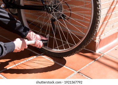 Man inflating the wheel of his bicycle before leaving for the mountain route. Concept: mountain bike