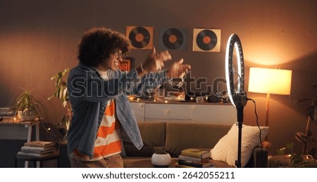 Man, influencer and dancing with ring light at house for introduction, late live streaming and social media. Night, content creator and audition for audience, filming video and tutorial challenge