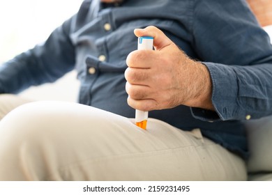 Man Injecting Epinephrine Using Auto-injector Syringe As An Emergency Treatment For Allergic Reaction