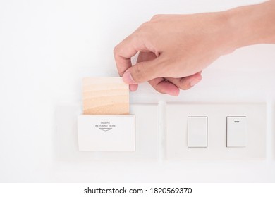 man insert keycard in electronic keycard holder in luxury hotel room