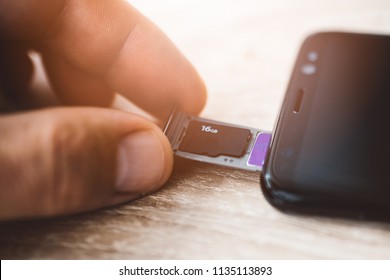 Man inserting memory card and sim card to smartphone