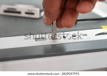 Man inserting an Usb flash drive in to a personal computer.