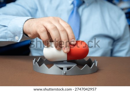 A man inserts a medication capsule into a trap. Drug addiction and medical collusion highlighting pharmaceutical abuse regulatory failure and healthcare ethics concerns.