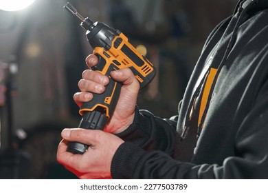 a man inserts a replacement battery into an electric wrench