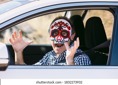 Man inside a car with a Hallowwen skull mask scaring