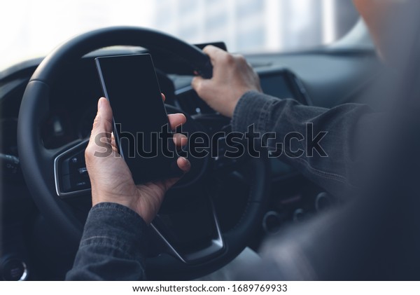 Man inside a\
car hand using mobile smart  phone with map gps navigation. Driver\
searching location via locator navigator application on smartphone,\
mock up, close up
