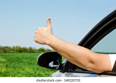 Man inside car showing thumb up outdoor