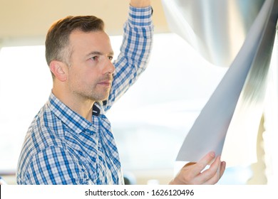 Man Inspecting Very Thin Aluminum Sheet