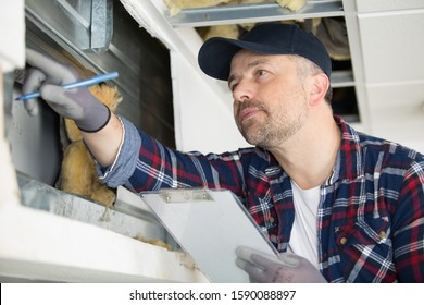 A Man Inspecting Wall Cavity