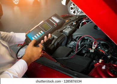 Man inspection holding Battery Capacity Tester Voltmeter.for service  maintenance of industrial to engine repair.In Factory transport automobile automotive image