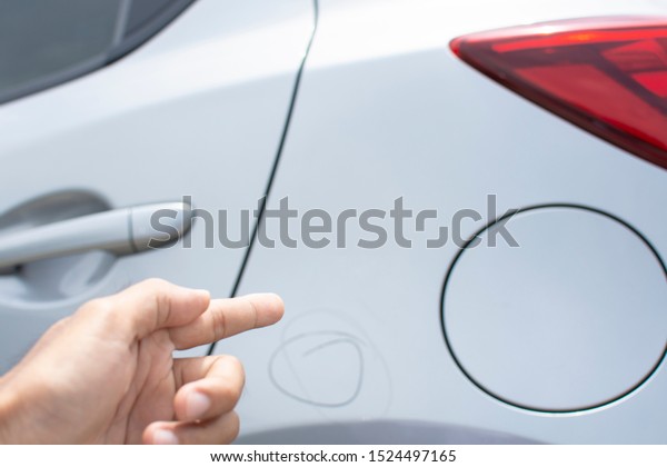 Man\
inspection Pointing finger trace marking point with car Fuel tank\
cap waiting for repair on car dealership in garage parked in\
showroom of automobile automotive for\
insurance