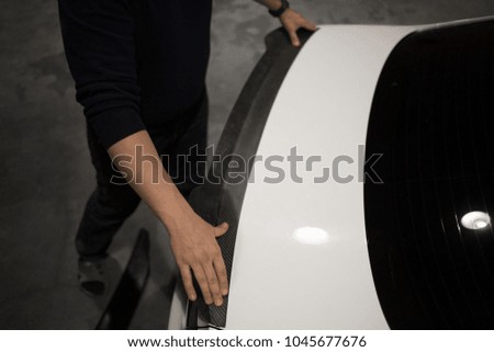 Man instal spoiler on the trunk of the car