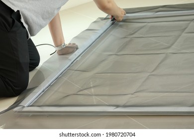 Man Install Mosquito Net Wire Screen On House Window Protection Against Insect