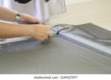 Man Install Mosquito Net Wire Screen On House Window Protection Against Insect