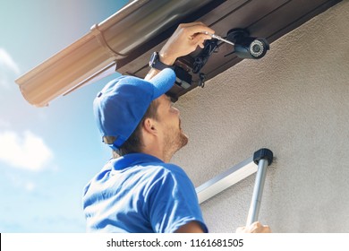 Man Install Outdoor Surveillance Ip Camera For Home Security