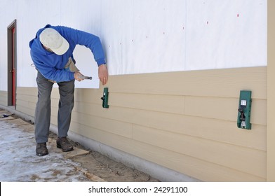 Man Installing Fibrous Cement Siding Using Siding Gauges