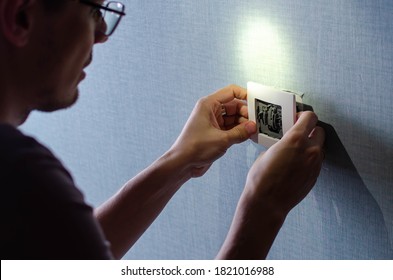 Man installing frame light switch after home renovation