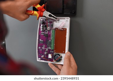 Man installing home security alarm system on gray wall, closeup - Shutterstock ID 2395448931