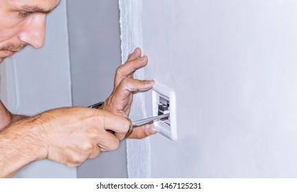Man installing light switch after home renovation