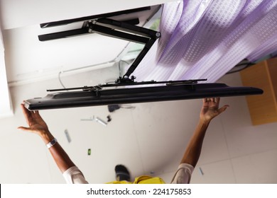 Man Installing Mount TV On The Wall At Home