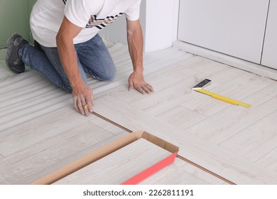 Man installing new laminate flooring indoors, closeup - Shutterstock ID 2262811191