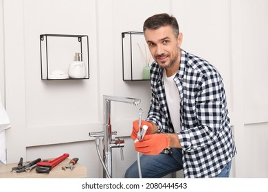 Man Installing New Water Tap In Bathroom