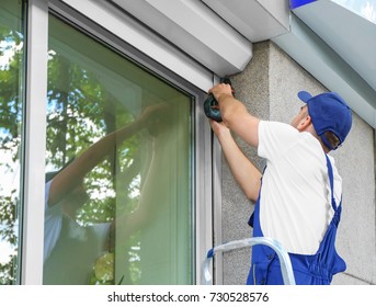 Man installing roller shutter on window