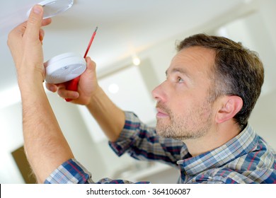 Man Installing A Smoke Alarm