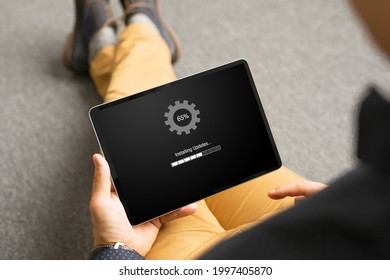 Man Installing Software Updates On Tablet Computer