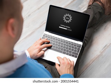 Man Installing Software Updates On Laptop Computer