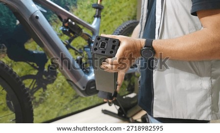 Man installing a Specialized e-bike internal battery in a bicycle frame lightweight electric bike