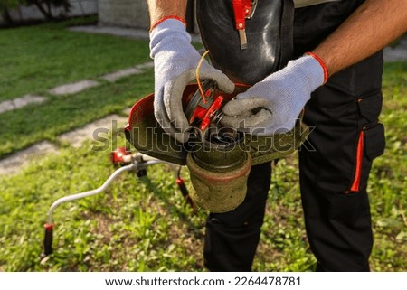 Man installing a string for cutting grass in his garden.
