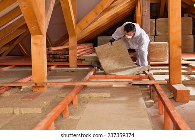 Man Installing Thermal Insulation Layer Under The Roof - Using Mineral Wool Panels