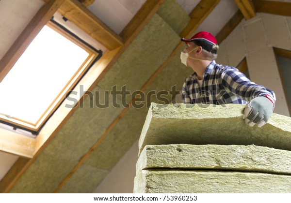 Man Installing Thermal Roof Insulation Layer Stock Photo