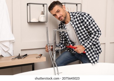 Man Installing Water Tap With Shower Head In Bathroom