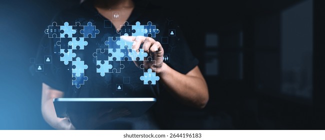 Man interacting with digital puzzle pieces over a world map, futuristic digital style, dark blurred background, concept of global teamwork and collaboration