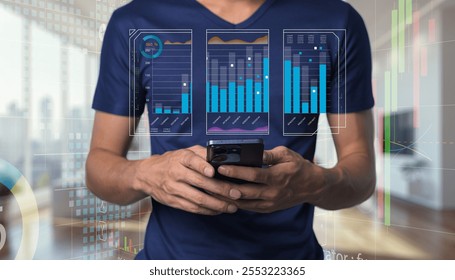A man interacts with his smartphone while analyzing digital graphs and charts in the background, showcasing a modern approach to data-driven business insights and technology.