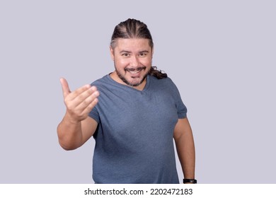 A Man Invites Someone To Come Closer, Gesturing With His Hands. Isolated On A Gray Background.