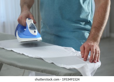 Man ironing clean shirt at home, closeup - Shutterstock ID 1953491524