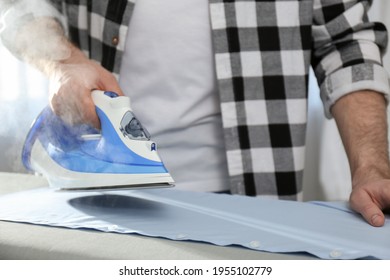 Man ironing clean shirt at home, closeup - Shutterstock ID 1955102779