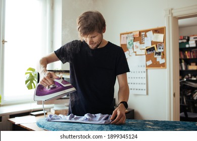 Man Ironing Clothes In Living Room. Daily Life At Home. Family Time In Video Call. Ironing Board And Laundry. Life In Quarantine During Self Isolation. Male Housekeeping And Daily Routine